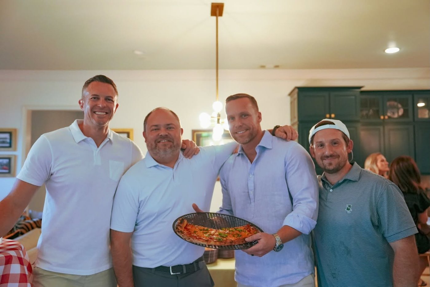 Four Veritas partners with a pizza at the annual margs and margs party.